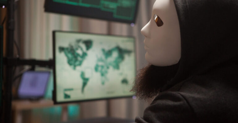 Bearded hacker with a hoodie wearing a white mask